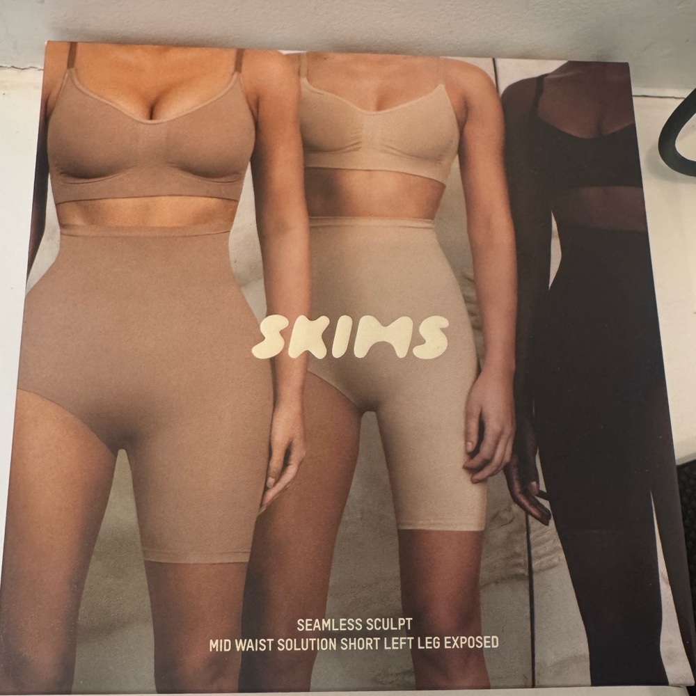 SKIMS Seamless Sculpt Mid Waist Shorts left leg exposed - Clay